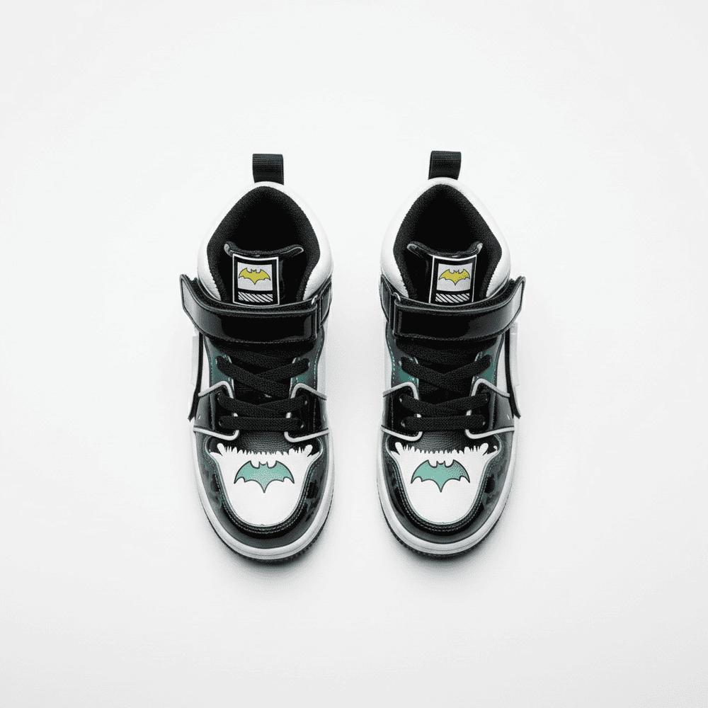 Black and white Batman-themed high-top sneakers for kids with glowing bat logo, velcro straps, and comic-book inspired details.