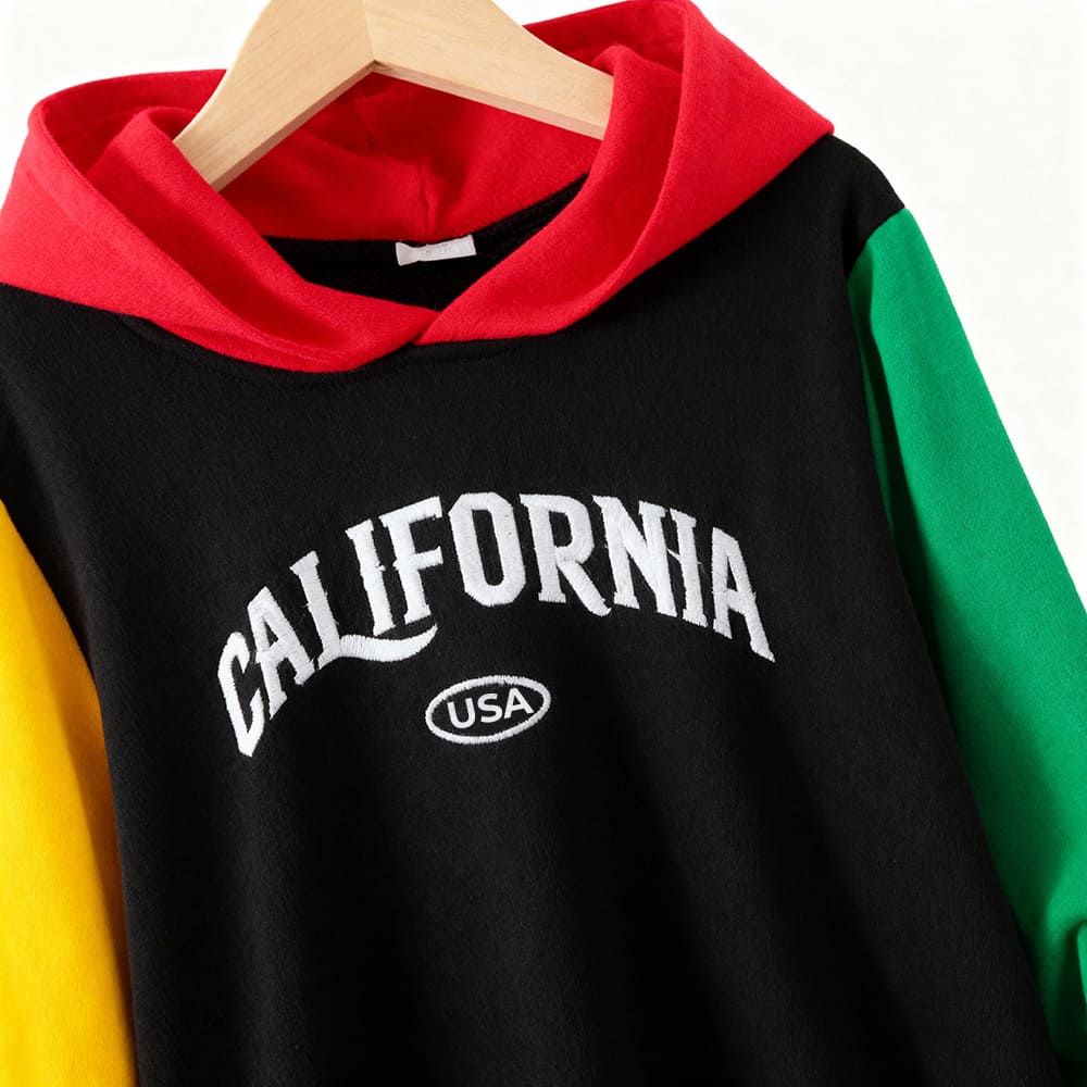 california-hoodie-top-styles-by-syl-1 Black colorblock hoodie with “CALIFORNIA” graphic, red hood, yellow & green sleeves — sporty, bold outfit for boys.