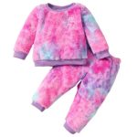 A vibrantly colored toddler girls' fuzzy loungewear set in tie-dye shades of pink, purple, and blue. The set includes a long-sleeve crewneck pullover top and matching jogger pants with elastic cuffs, laid flat on a white fluffy rug.