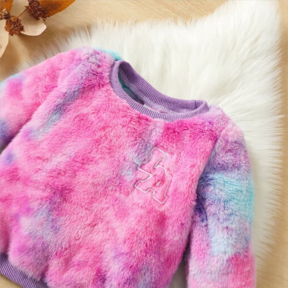 A vibrantly colored toddler girls' fuzzy loungewear top in tie-dye shades of pink, purple, and blue.