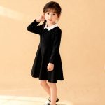A girl on Black long-sleeve dress with white Peter Pan collar.