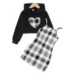 Girl wearing black hoodie with plaid heart and black-and-white plaid dress
