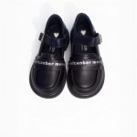Girl’s black Mary Jane shoes with white lettering strap and heart detail