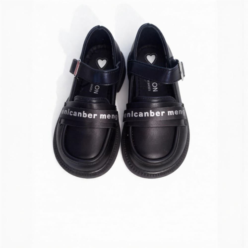Girl’s black Mary Jane shoes with white lettering strap and heart detail