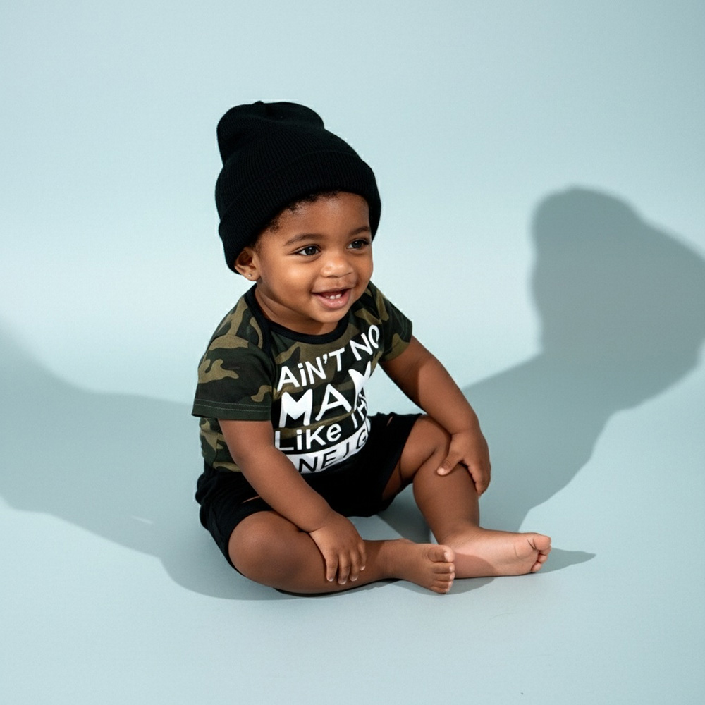 Camo bodysuit with “Ain’t No Mama Like The One I Got” + black shorts and hat