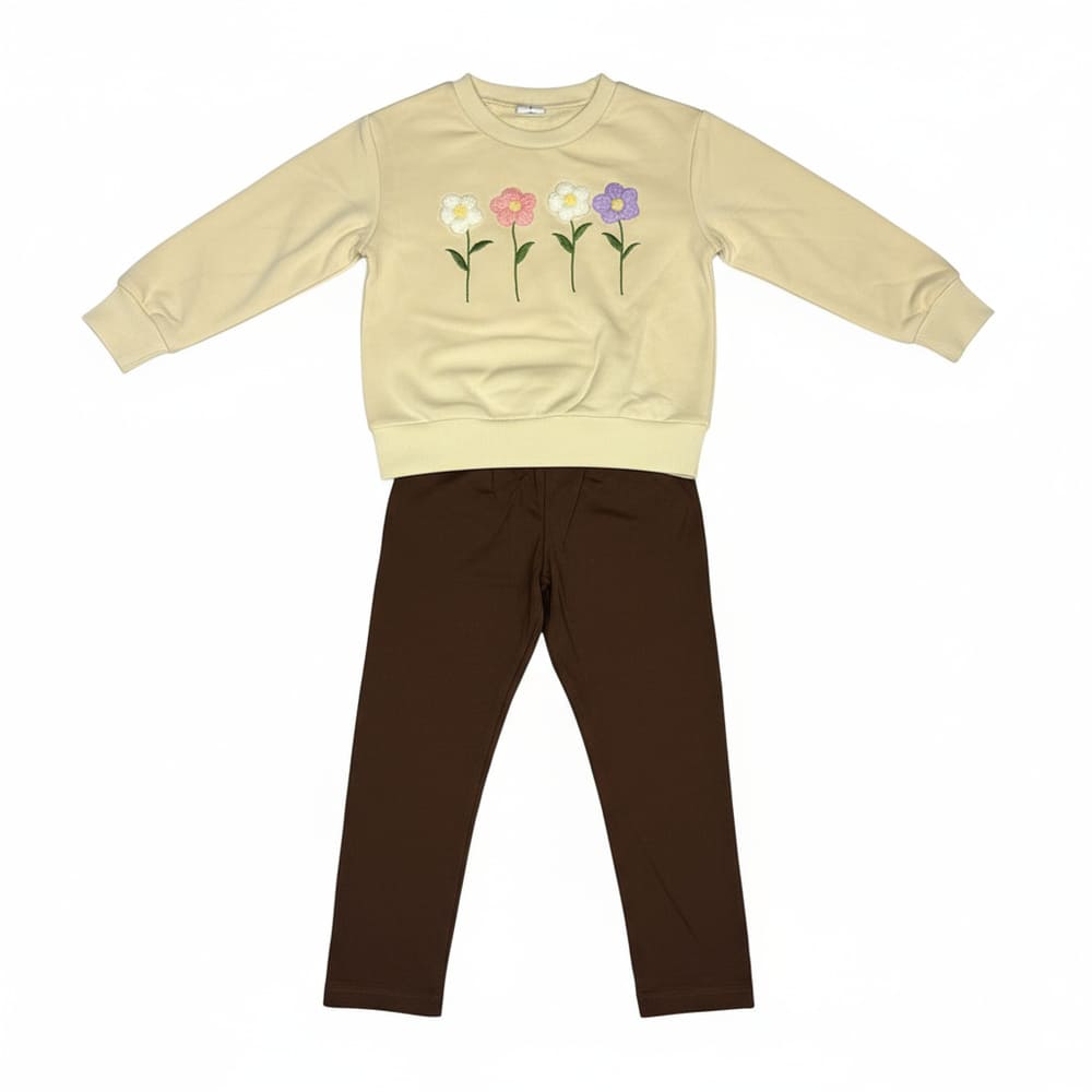 Girl wearing cream flower-embroidered sweatshirt and brown leggings
