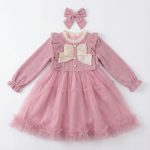 Girl wearing pink corduroy tutu dress with matching headband