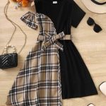 Girl wearing black and beige plaid asymmetrical dress with bow belt