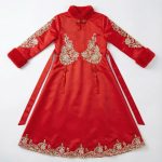 Girl wearing red silk cheongsam with gold embroidery and tassels