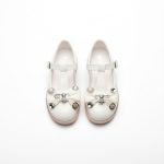 Girl’s white Mary Jane shoes with pearl bow and rhinestone details