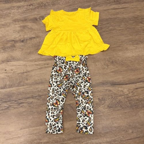 Girl wearing yellow ruffle top and leopard butterfly pants